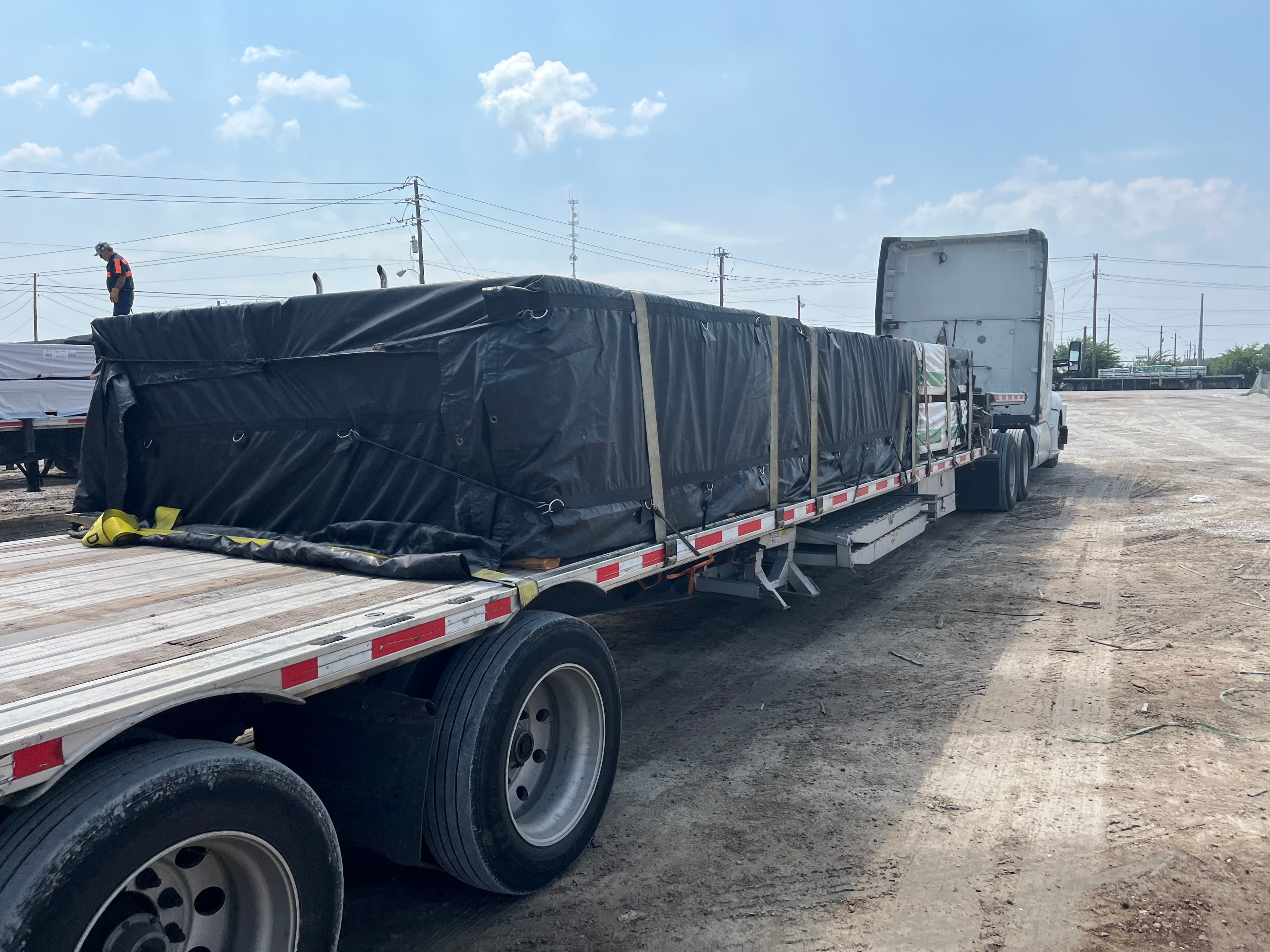 Tarped flatbed hotshot load secured for time-critical delivery